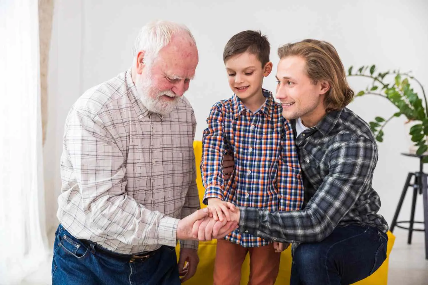 Three generations of a family joining hands together at home